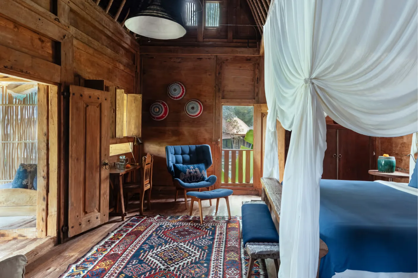 Im Inneren eines alten Teakhauses, mit Himmelbett