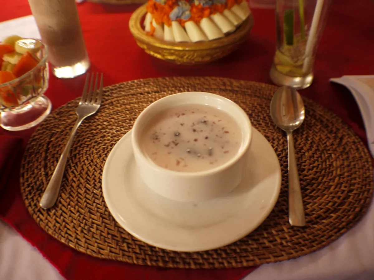 Bol de riz gluant noir nappé de lait de coco en spirale