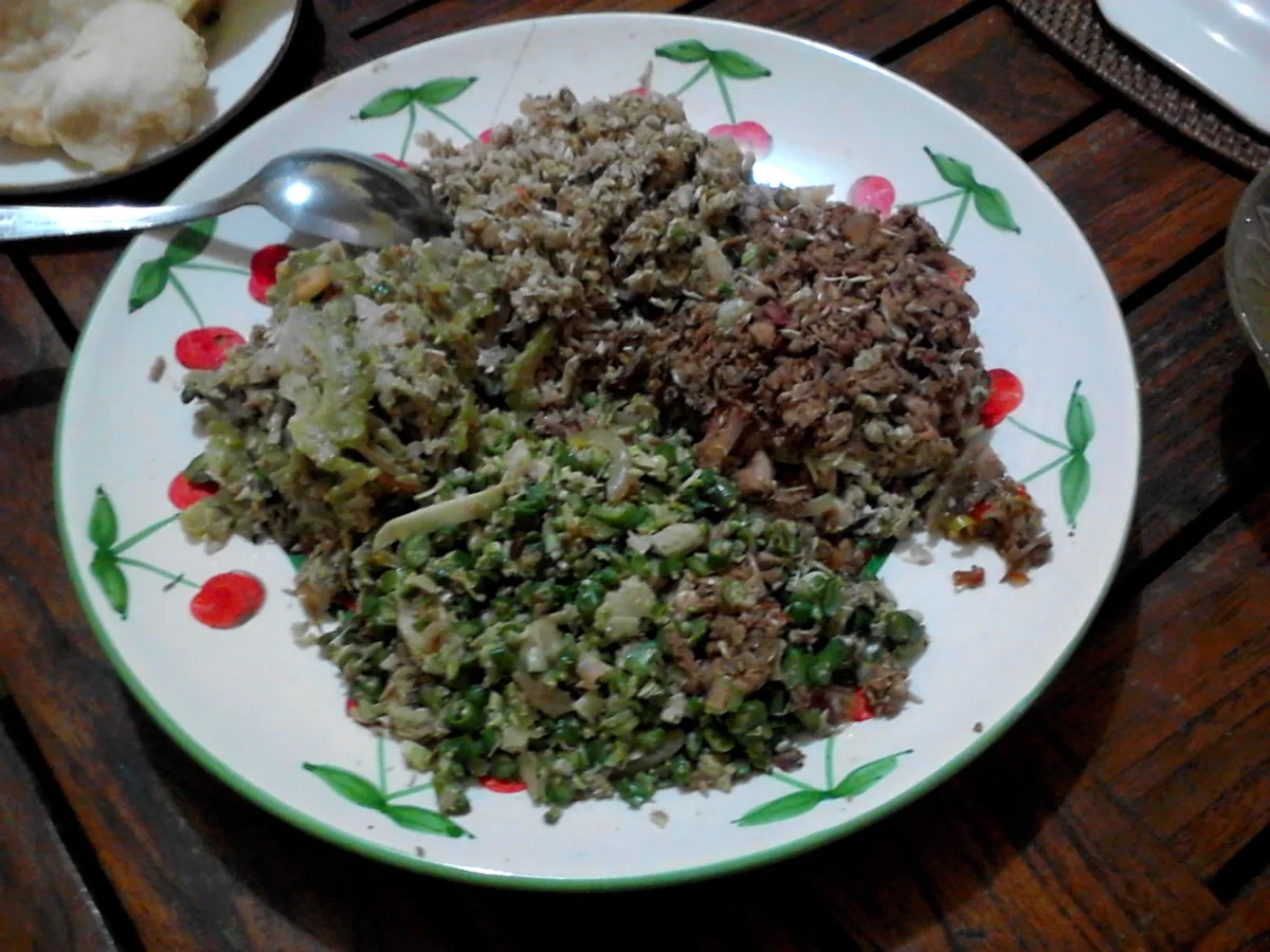 Assiette de lawar : légumes hachés, noix de coco râpée et viande épicée