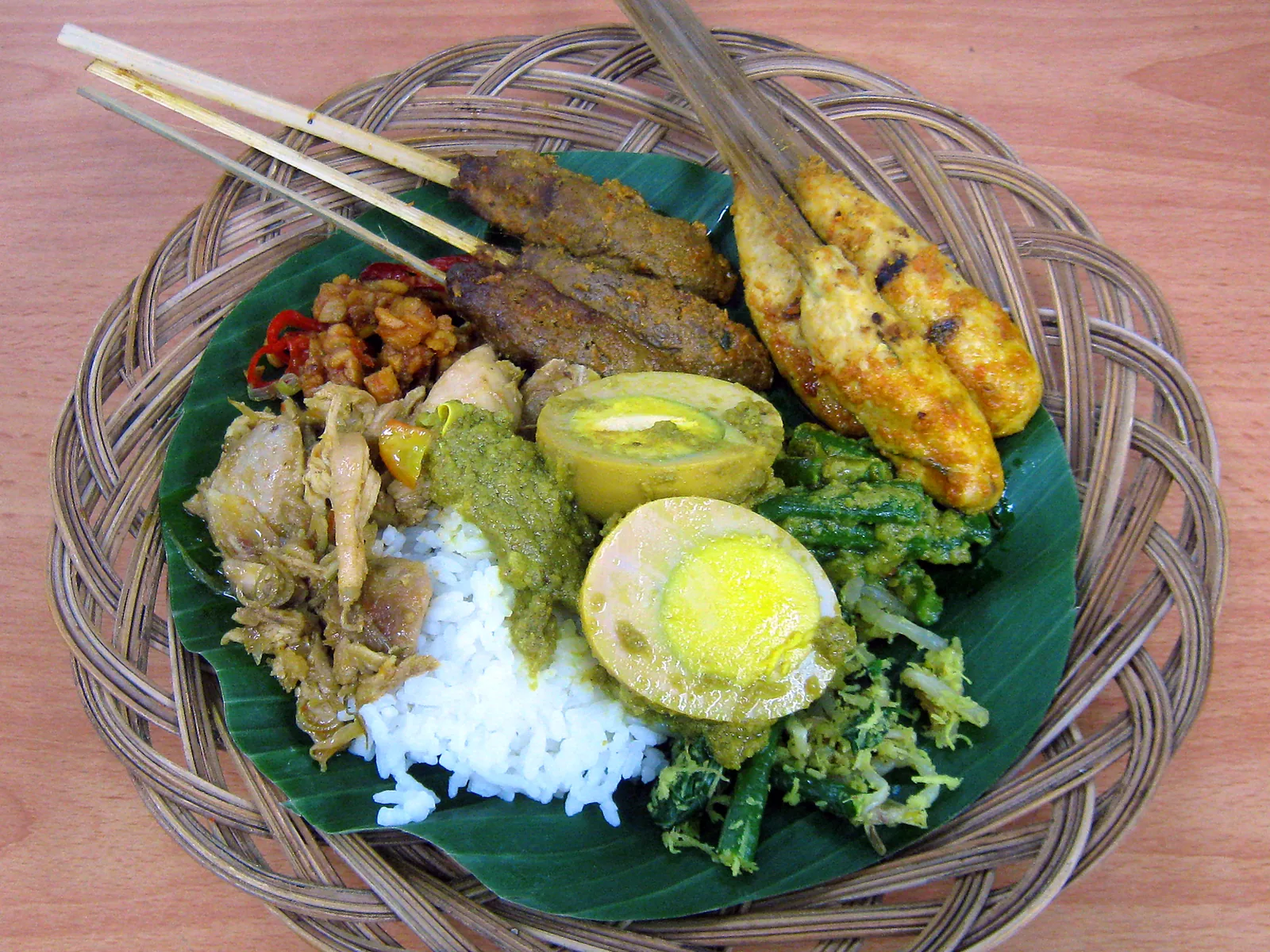 Nasi campur balinais sur feuille de bananier : riz, sate lilit, œuf, poulet et légumes