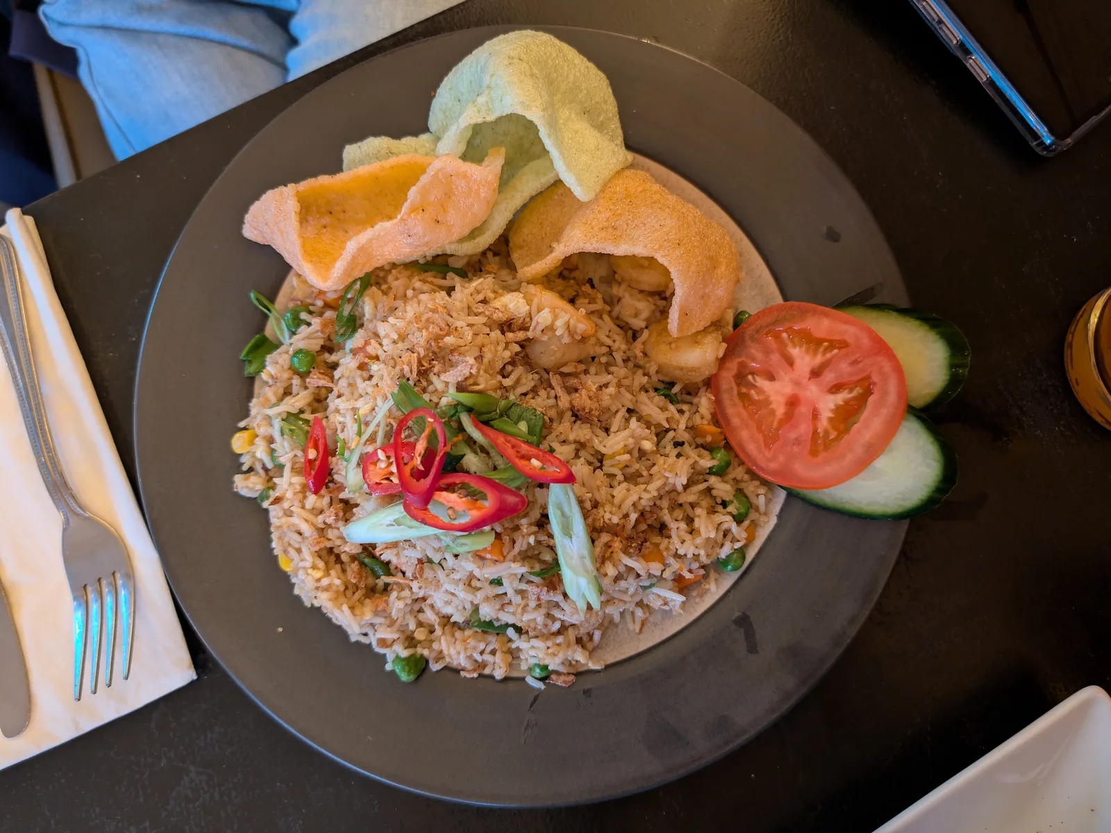 Assiette de nasi goreng aux crevettes avec chips de crevette, tomate et piments